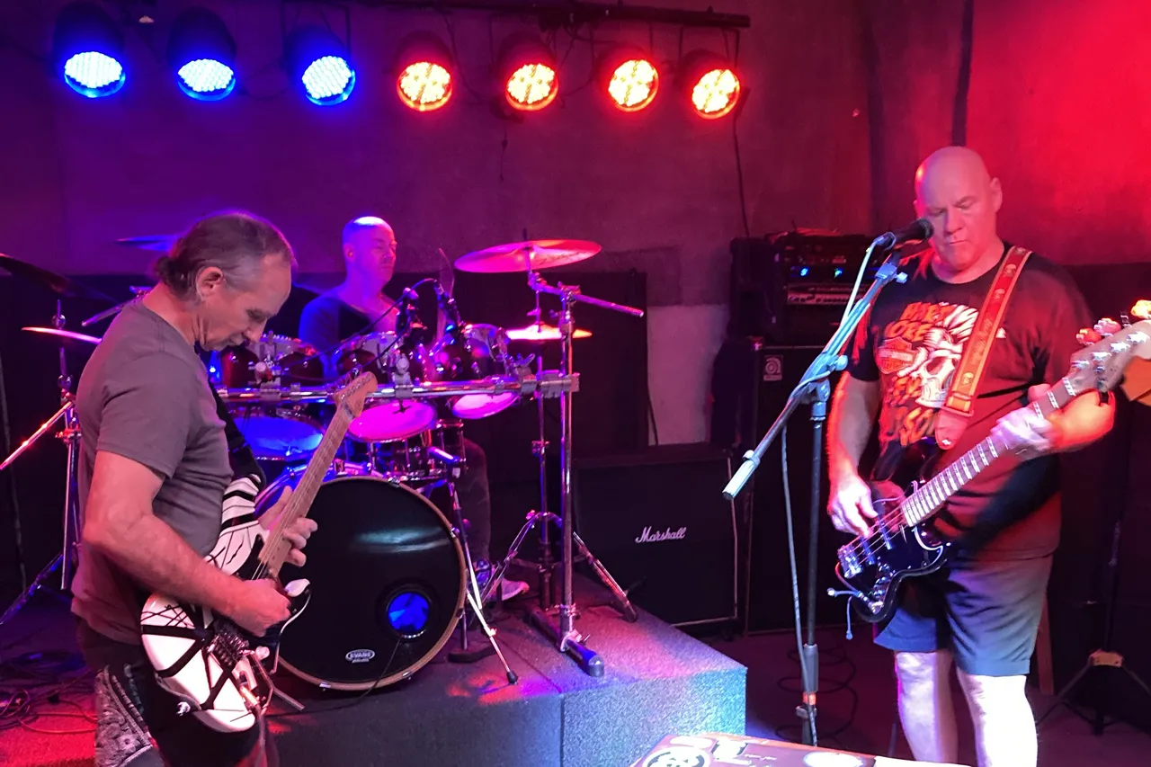 A live band playing under stage lights at Lights, Action, Music Studios in Longwood, FL